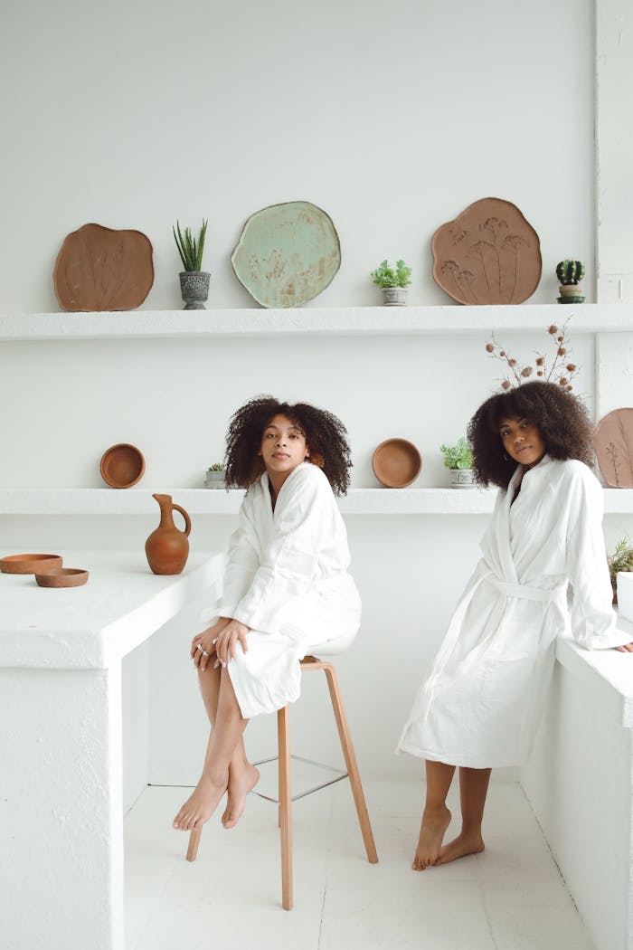 Two women enjoying a relaxing skincare routine in a modern spa with pottery decor.