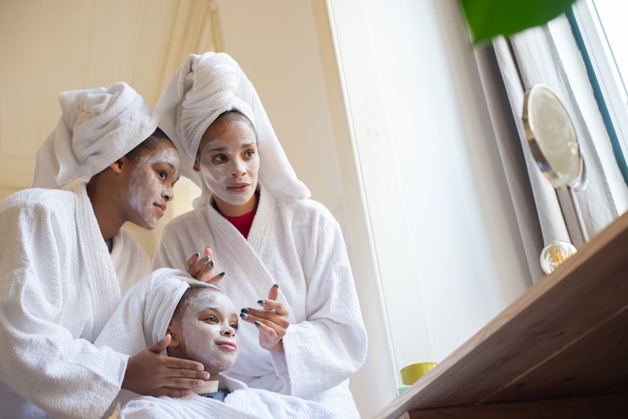 A family enjoys a home spa day together, wearing bathrobes and facial masks.